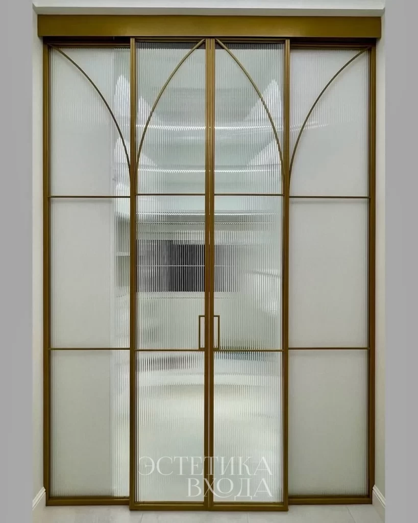 Перегородка для гардеробной комнаты с радиальным золотым профилем и вставками из рифленого стекла.